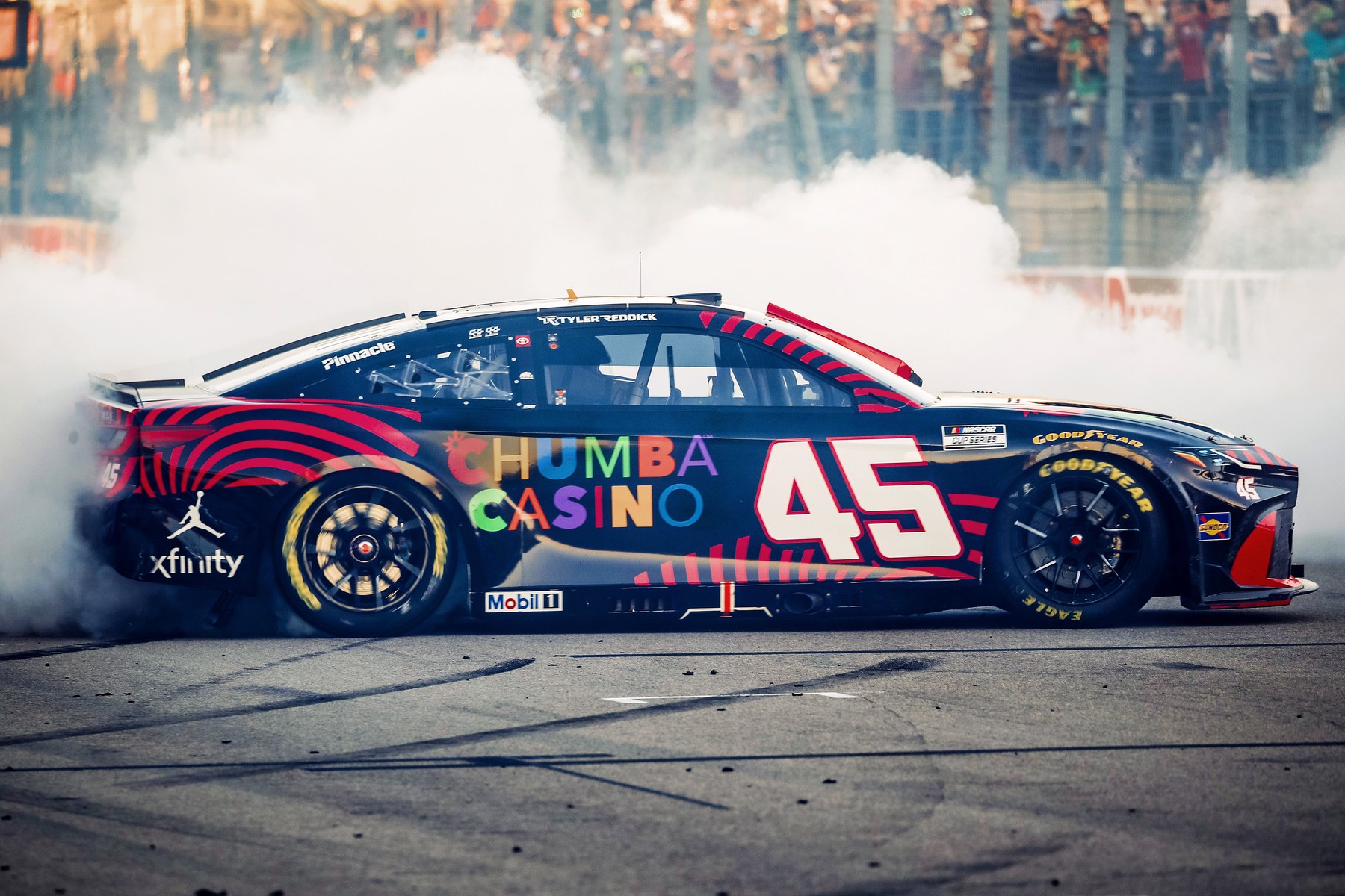 The number 45 Chumba Casino car performing a burnout in front of the crowd